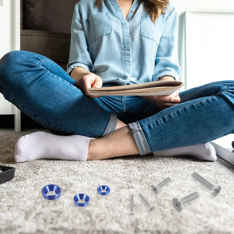 Person sitting with Alloy Countersunk Washer Kit With Handy Storage Box, colorful washers and screws on the carpet.