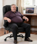 Man sitting on Big And Tall Executive Office Chair With Flip Up Armrests, Heavy Duty PU Leather Desk Chair, in home office