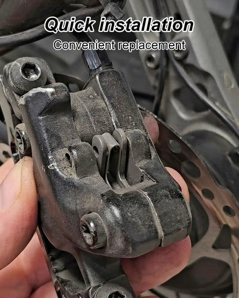 Close-up of a hand holding a brake caliper in an electric bike, showcasing Beefy Electric Bike Brake Pad Set With Quiet Braking.