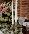 Flameless Taper Candles 11 Inch Ivory Wax Covered LED Flicker With Remote Controls And Timer 10 Pack For Weddings Family Dinners Parties Festive Home Decor displayed in a centerpiece arrangement.