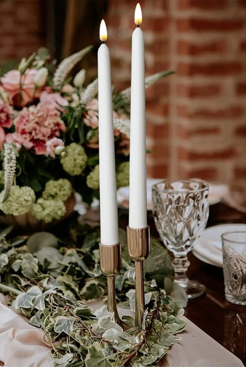 Flameless Taper Candles 11 Inch Ivory Wax Covered LED Flicker With Remote Controls And Timer 10 Pack For Weddings Family Dinners Parties Festive Home Decor displayed in a centerpiece arrangement.