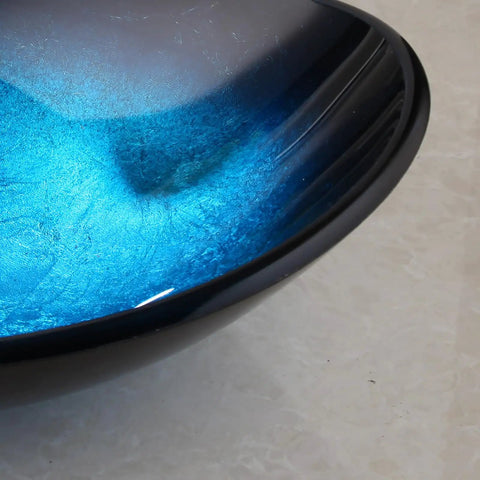 Close-up of Blue 21 Inch Oval Glass Vessel Sink With Faucet And Pop Up Drain Above Counter Modern Bathroom Vanity Setup.