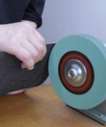 Hella Durable 8 Inch Polyurethane Buffing Wheels 2000 Grit Silicon Carbide Abrasive being used on a bench grinder for metal polishing.