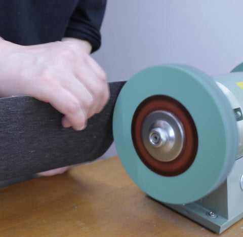 Hella Durable 8 Inch Polyurethane Buffing Wheels 2000 Grit Silicon Carbide Abrasive being used on a bench grinder for metal polishing.