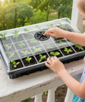 Child examines 24 Cell Seed Starter Tray With Dome For Easy Seed Starting, 5 Pack 2 Inch Plug Trays Totaling 120 Cells, outside on railing.