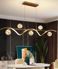 Modern Linear Pendant Light Set Featuring Six Glass Globe Shades Dimmable Gold Kitchen Island Fixture above a dining table.