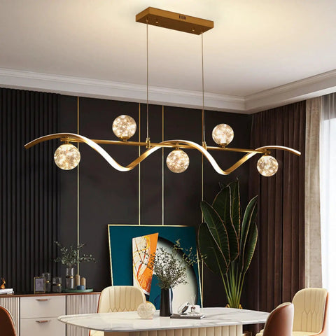 Modern Linear Pendant Light Set Featuring Six Glass Globe Shades Dimmable Gold Kitchen Island Fixture above a dining table.