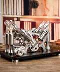 Heavy Duty Four Cylinder Stirling Engine Model In Atmospheric Black With Solid Brass Drive Train And Smooth Flywheel Motion on desk.
