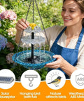 Woman holding solar cascade hanging bird bath fountain with solar pump and bowl, blue finish, for garden yard patio decor