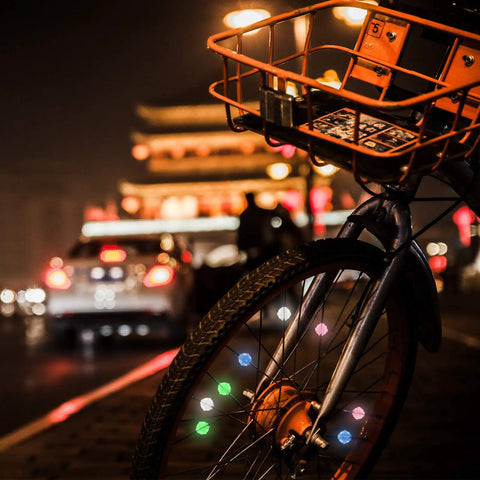 Bike with Glow In The Dark Bike Spoke Beads For Kids Set Of 216 Colorful Plastic Round Spoke Decorations on street at night