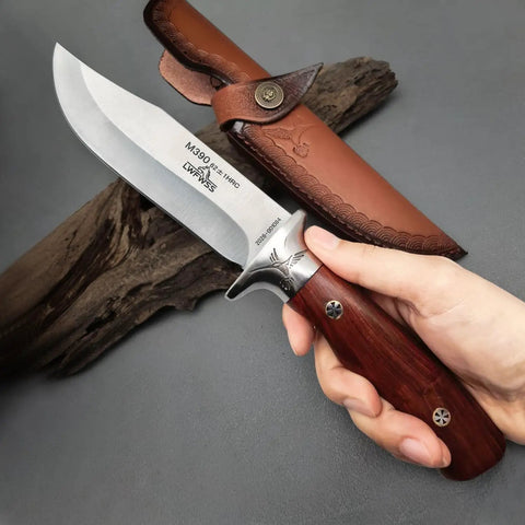 Hand holding M390 Fixed Blade Hunting Knife With Wood Handle Full Tang Survival Knife Leather Sheath Built For Rugged Outdoor Camping Bushcraft And Beast Mode Wilderness Tasks No Cap, showing blade detail and sheath.