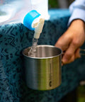 All-In-One Stainless Steel Cup And Pot, 24 Oz, Lightweight, being filled with water for camping and outdoor use
