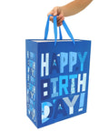 Ultra Large Sixteen Point Five Inch Blue Gift Bags Set With Greeting Card And Tissue Paper held by hand, for birthday parties.