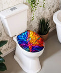 Round Colorful Stained Glass Effect Abstract Leaf Radiant Toilet Seat on a white toilet with lush green plants in the background.