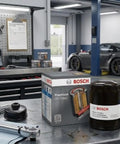 Premium Oil Filter With Filtech Filtration Technology in workshop, showcasing packaging and filter for Acura, Honda, Infiniti, Nissan vehicles.