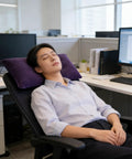 Person in office chair using Inflatable Neck And Lumbar Support Travel Pillow For Office Car Camping Hiking And Naps Dark Blue Color Super Cozy Yet Firm Easy To Inflate Adjustable Firmness Lightweight And Portable For All Day Comfort On The Go