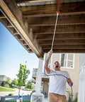 Man using Built Tough Airless Paint Spray Gun With Nozzle Guard For Pump Sprayer 3600 Psi to spray under a wooden structure.