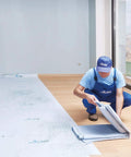 Worker applying Temporary Floor Protection Roll 36 Inch By 100 Foot Anti Slip Surface Easy To Apply Paint Proof Reusable Durable Material