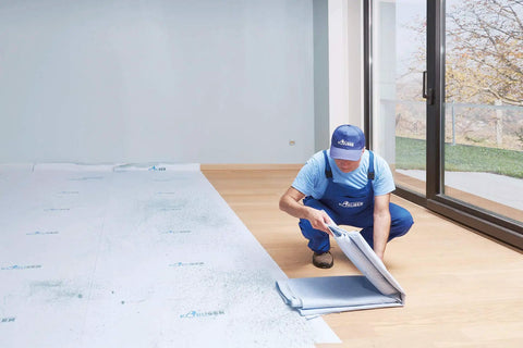 Worker applying Temporary Floor Protection Roll 36 Inch By 100 Foot Anti Slip Surface Easy To Apply Paint Proof Reusable Durable Material