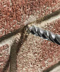 Pro Grade 14 Piece Fast Spiral Rotary Masonry Bit Set drilling into brick, showing carbide head making clean cuts.