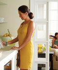 Woman using High Arc Pulldown Bar Faucet With One Handle Chrome Finish, Reflex Technology in a modern kitchen setting, smooth water flow.