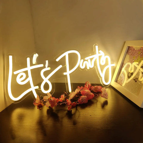 Lets Party Neon Sign Dimmable LED Neon Light For Wall Decor 16x7 Inches Word Sign glowing warmly on a table with flowers