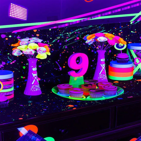 Neon party setup with floral decor and cupcakes under Two Pack 100W UV Black Lights For Glow Parties And Stage Lighting IP65 Waterproof Beefy Ultraviolet Lamps For Halloween Body Paint And Fluorescent Posters Neon Glow Effects.
