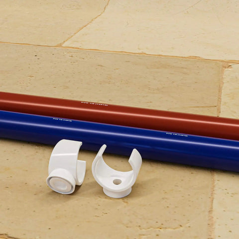 1 Inch PEX Pipe Support Hangers Set Of 130 U Hook PVC Clamps for Water Lines with red and blue pipe on stone floor