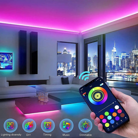 Smartphone controlling 100Ft RGB LED Strip Lights Kit With 2 Rolls Of 50Ft, illuminating a modern living room in various colors.