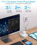 7 in 1 European Travel Plug Adapter with USB ports and AC outlets, charging multiple devices simultaneously in a workspace.