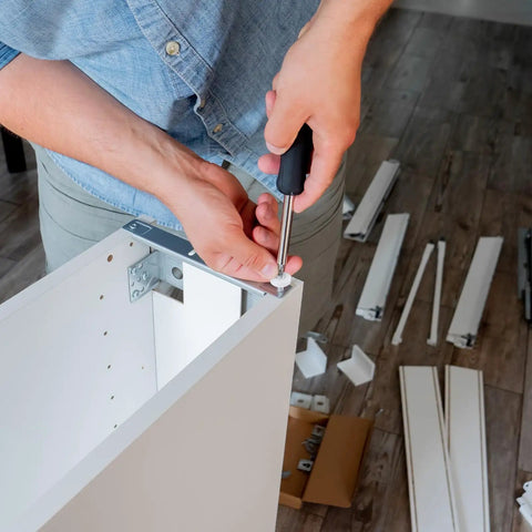 Person installing Six Piece Set Of 19mm White Plastic Drawer Rollers Featuring Slick Cabinet Pulleys on a drawer.