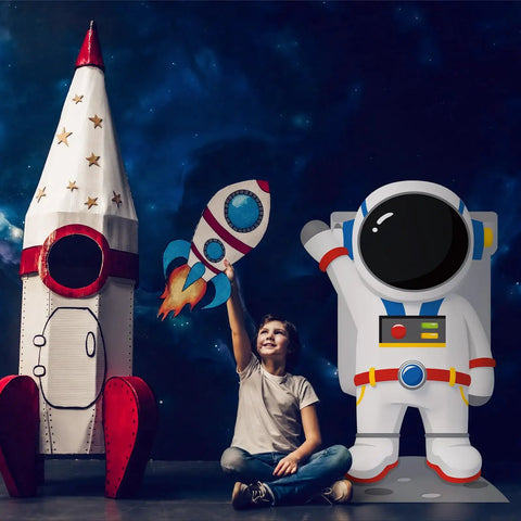 Child playing with rocket toy next to 4.67 Ft Astronaut Cardboard Cutout For Space Party Stand Up Backdrop And Photo Prop