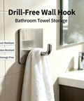 Rock Solid Self Adhesive Wall Hooks Crafted From Premium Stainless Steel For Zero Drill Wall Mounting And Effortless Home Organization With A Smooth Silver Look Set Of Four holding a towel in a bathroom.