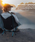 Person sitting on ultralight backpacking camp chair at mountain overlook, chair packs smaller than a water bottle, weighs 1.1 lbs