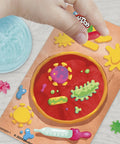 Light-Up Microscope Toy For Kids With Glow Reveal And 9 Accessories In 5 Colors, showing slide on nature mat