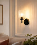 AOIOUR 10.4" 1‑Light Farmhouse Vanity Wall Sconce, Ribbed Glass Matte Black mounted beside a couch, softly illuminating the room.