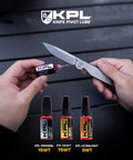 Applying Pocket Knife Oil Combo Pack With Original Heavy Ultralight Variants Blade Lube on a folding knife, 3 X 10ml bottles shown.