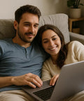 Couple sitting on a couch using a laptop, enjoying leisure time together.