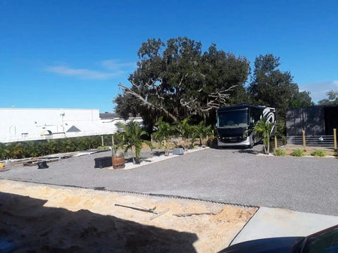 Vodaland Permeable Pavers EasyPave Driveway Grid in backyard with gravel surface, trees and parked vehicle visible