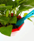 Blue hand shovel from Four Piece Eight Inch Trowel Set With Colorful Metal Hand Shovels for Beach Garden and Planting tasks in red pot
