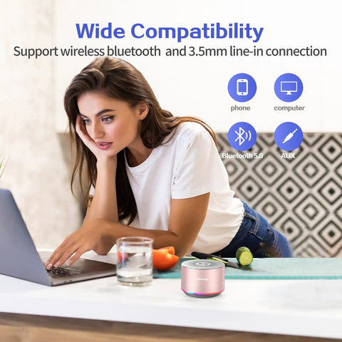 Woman using laptop with Tiny But Mighty Grab And Go Metal Bluetooth Speaker with Lights and Lanyard 5W Mini Wireless.