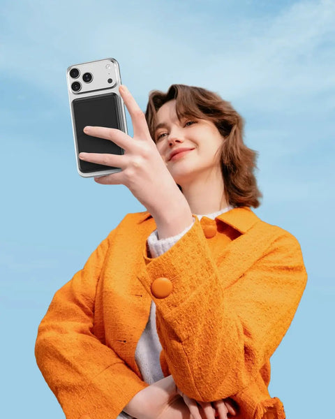 Compact Foldable MagSafe Power Bank 10000 Mah Featuring Dope Magnetic Alignment For iPhone 16 15 14 Series, held by a woman in an orange jacket.