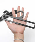 Set Of 50 Black Plastic Hangers For Home And Retail Display, 7.7 Inch Long shown in hand for scale