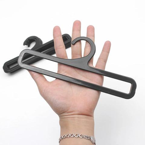 Set Of 50 Black Plastic Hangers For Home And Retail Display, 7.7 Inch Long shown in hand for scale