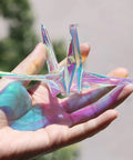 Iridescent Cellophane Wrapping Paper Roll For Flower Bouquets And Wine Bottles Multicolor Gift Wrap For Weddings And Parties Can Be Cut To Size Durable Packaging Paper For Gifts That Pop folded into origami crane on hand