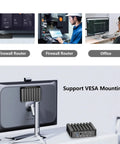 Heavy Duty Firewall Mini PC Router Harnessing Intel J6412 with VESA mounting support beside a monitor in an office setting.