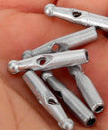 Handy Dandy 10 Piece Umbrella Tail Beads Kit For Foldable Repair And Sturdy Plastic Rib End Caps Easy Snap Fix keeps your rain gear snappy and dry through any storm weather. Silver plastic caps in a hand.