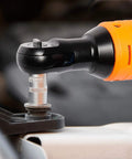 Cordless Three Eighths Inch Drive Ratchet Wrench Set With 12V Battery And Charger Kit in use, orange and black handle close-up