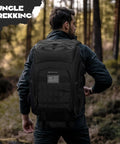 Tactical Backpack For Men 40L Water Resistant With Molle System For Hiking Camping And Gym, black rugged pack in forest
