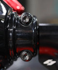 Close-up of Top Shelf Titanium Handlebar Clamp Bolts And Brake Clutch Perch Screws For Heavy Duty Motorcycles on black handlebar.